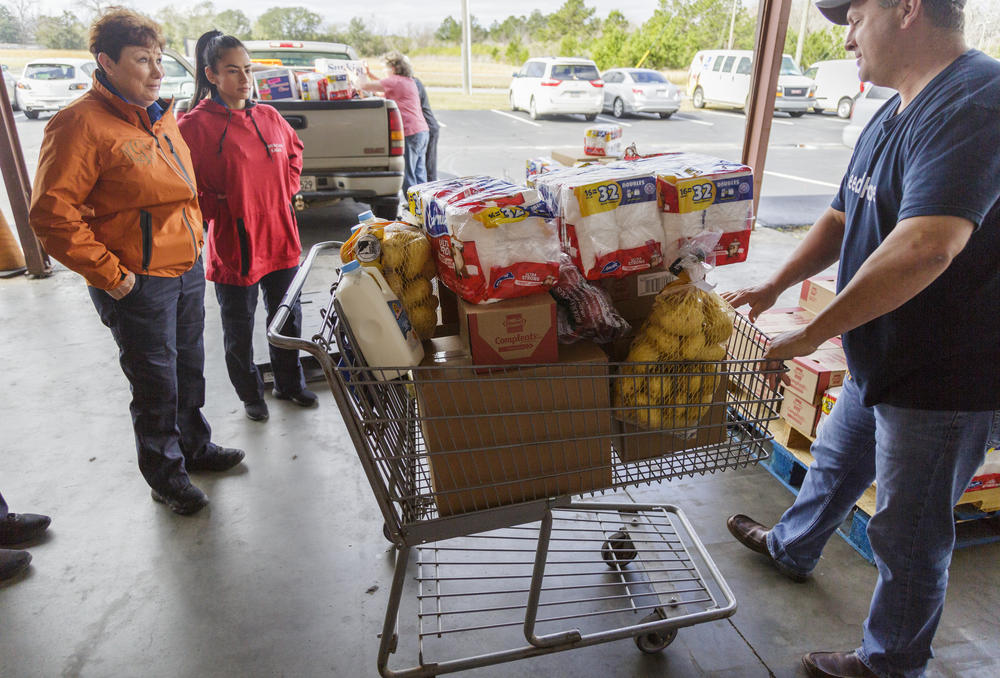 Douglas Griner, right, partner services director of the Second Harvest of South Georgia food bank in Valdosta, loads up food for three TSA workers Thursday morning.