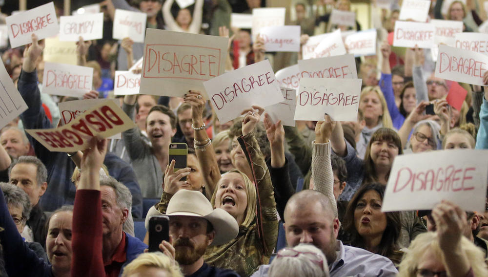 People react to Rep. Jason Chaffetz as he speaks during a town hall meeting at Brighton High School, Thursday, Feb. 9, 2017, in Cottonwood Heights, Utah. 