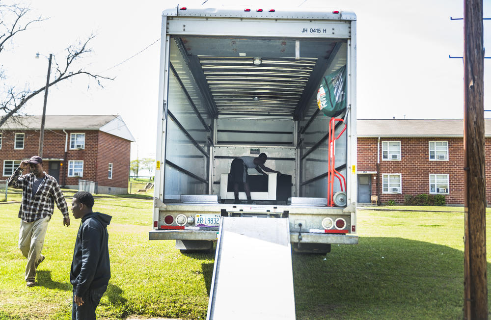 Kenny Howell Jr. slides his sofa into place in the back of a moving truck on the Wednesday he picked to move himself, his girlfriend and their three kids from the Tindall Heights Housing Project to a new rental house. 