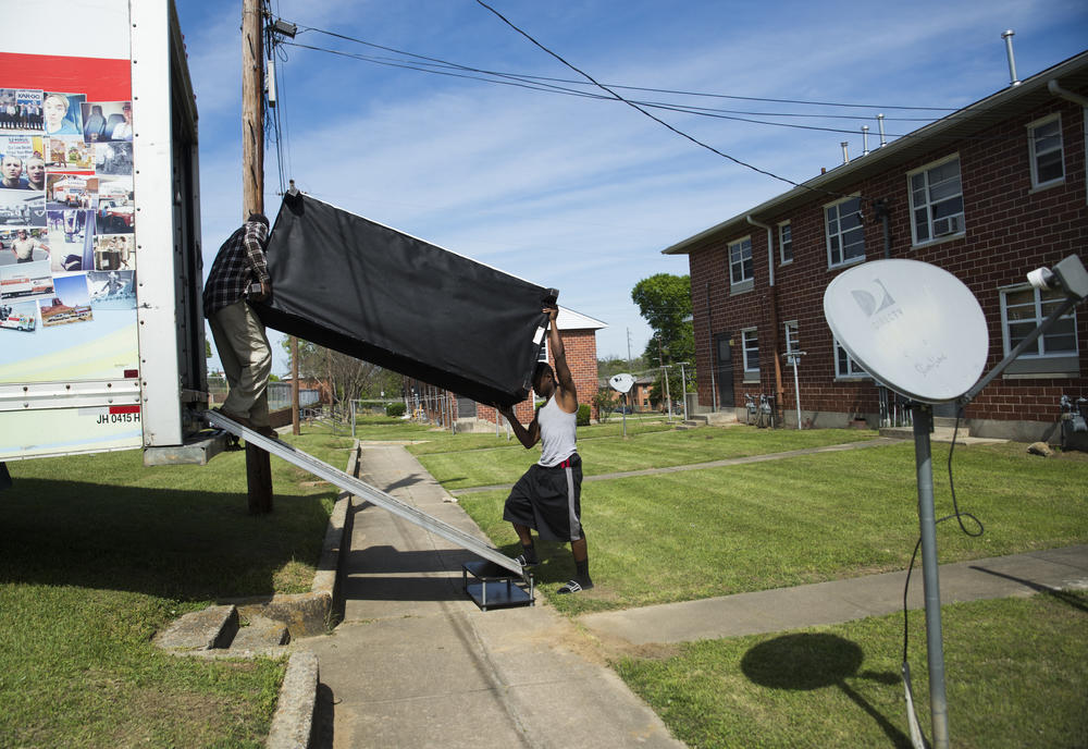 Kenny Howell Jr., right, lifts his sofa into place in the back of a moving truck with the help of a friend on the Wednesday he picked to move himself, his girlfriend and their three kids from Tindall Heights Homes to a new rental house. 