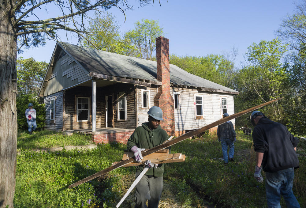 A crew works to demolish a home in Macon's Linwood Estates neighborhood in 2015. The original, Federal redlining maps from the 1930s said of Linwood 