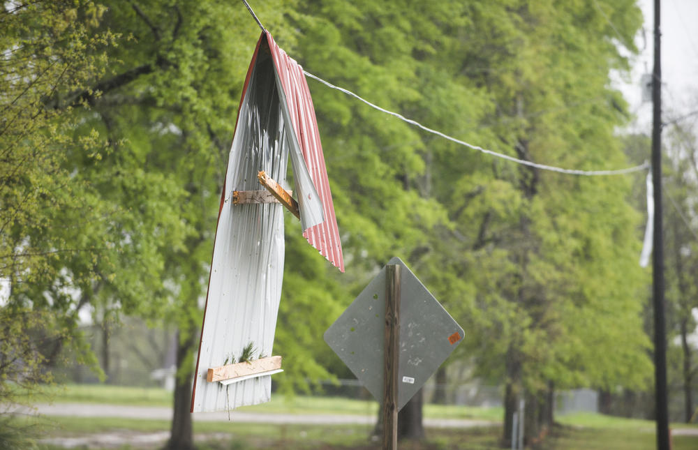 A piece of sheet metal roofing on a power line  near a handful of homes damaged by an apparent tornado in Twiggs County Friday. 