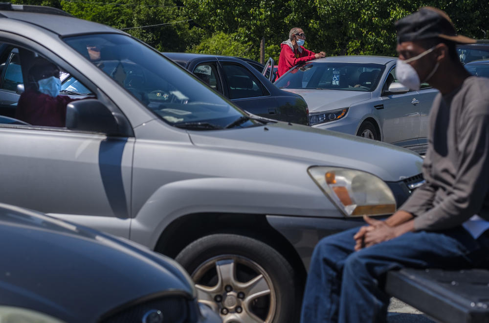 People wait for a Macon church to begin disbursing food  on Thursday, April 16. The church sits at the north end of a census block the Georgia Department of Health now says is a trouble spot for coronavirus infections in Macon-Bibb County. 