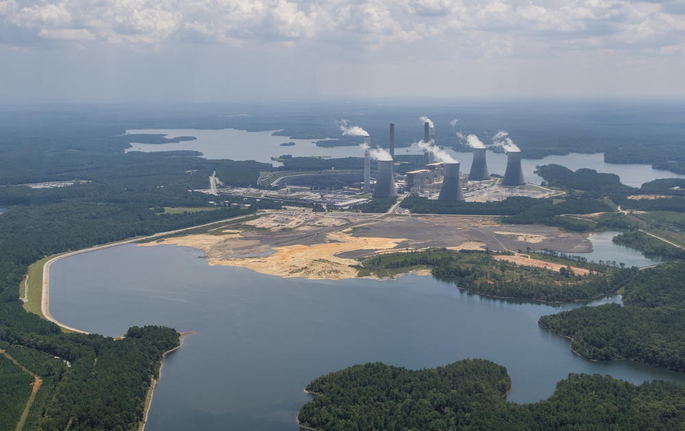 The coal ash pond, foreground, where waste from Georgia Power's coal fired Plant Scherer is stored, in August of 2019. The coal ash is partially submerged in the local aquifer.