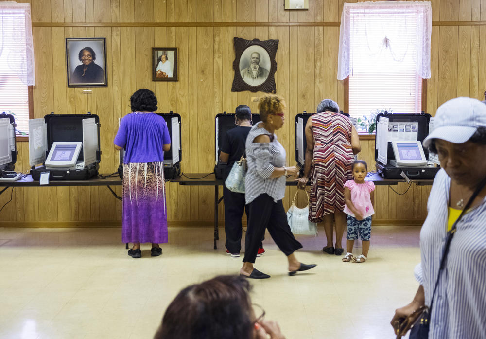 At the East Macon 4 Voting Precinct at New Griswoldville Baptist Church in Macon-Bibb County, 130 people had voted beneath portraits of church elders by 11 am on the first primary election day of 2018 in May. 