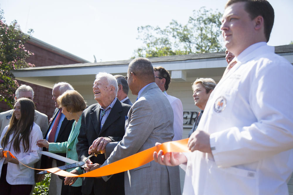 Former President Jimmy Carter wields the big scissors at the ribbon cutting of the new doctor's office opened his hometown of Plains. 