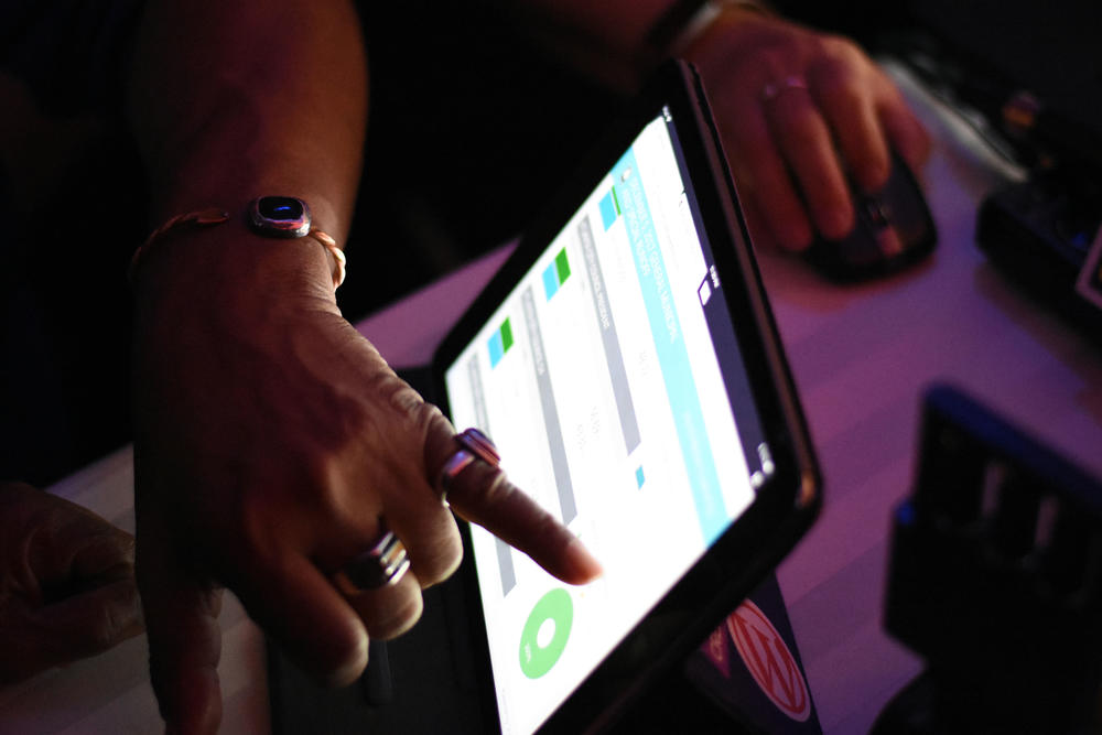 A woman points to election results on an iPad at Mary Norwood's watch party. After election night, Norwood trailed Keisha Lance Bottoms by 759 votes.