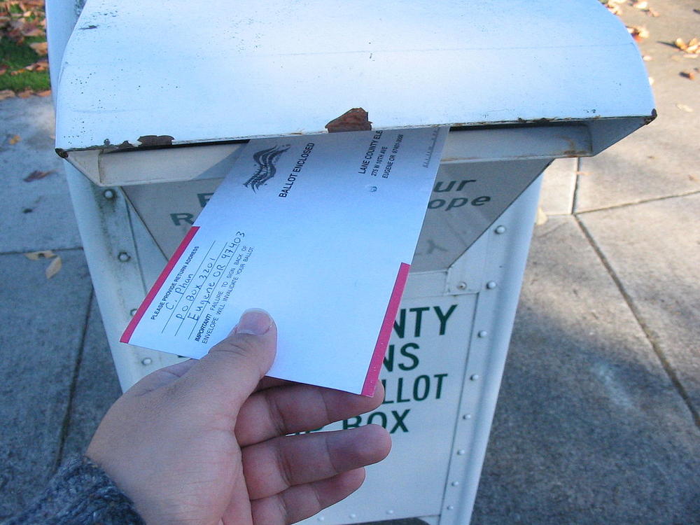 A voter returns his vote-by-mail ballot in Lane County, Oregon