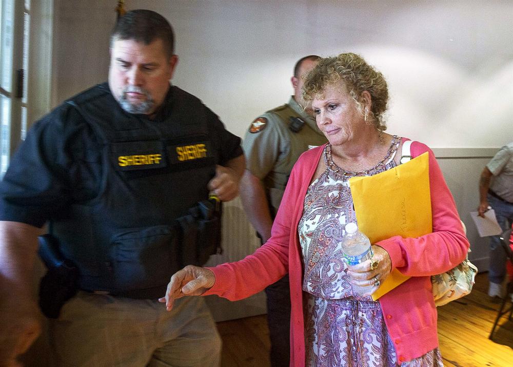 Hoschton Mayor Theresa Kenerly is escorted from the premises following a city council meeting at the Hoschton Historic Train Depot in Hoschton, Georgia on May 6, 2019.