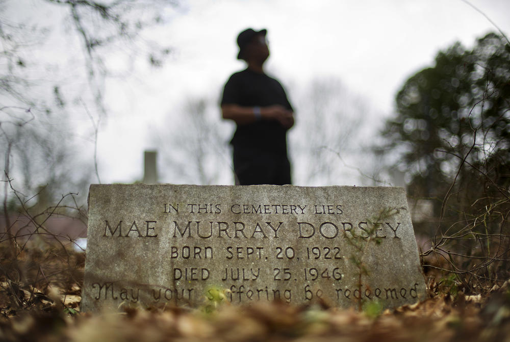 Tyrone Brooks, a veteran civil rights activist, stands behind the tombstone of Mae Murray Dorsey who was killed in a 1946 lynching by a white mob in Monroe, Ga., Thursday, Feb. 22, 2018.
