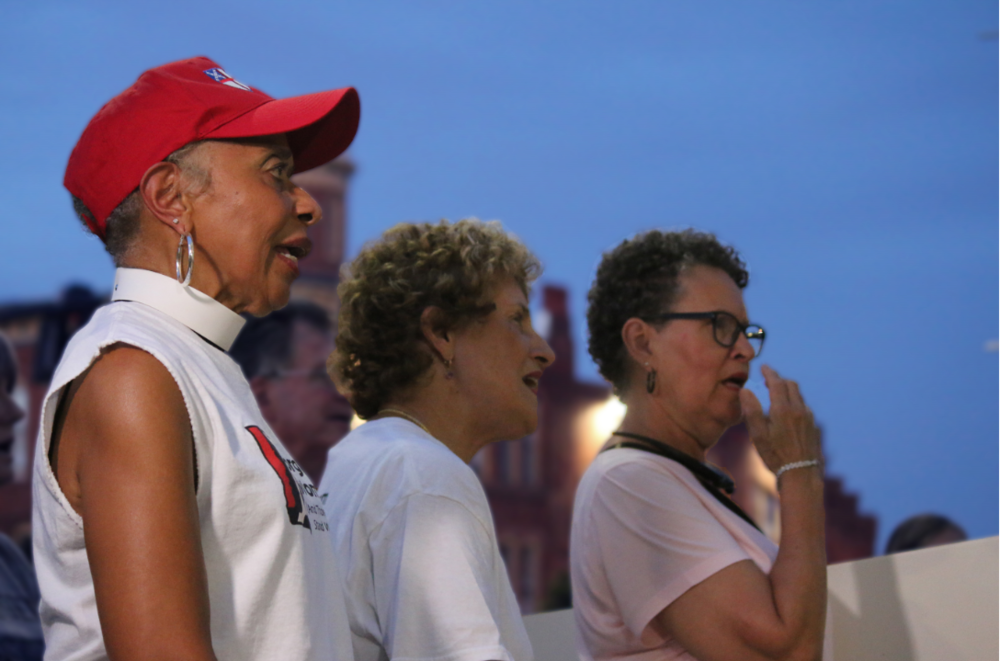 Janet Tidwell and Tracie Jenkins join in on a group song led by Rev. Cassandra Howe. 