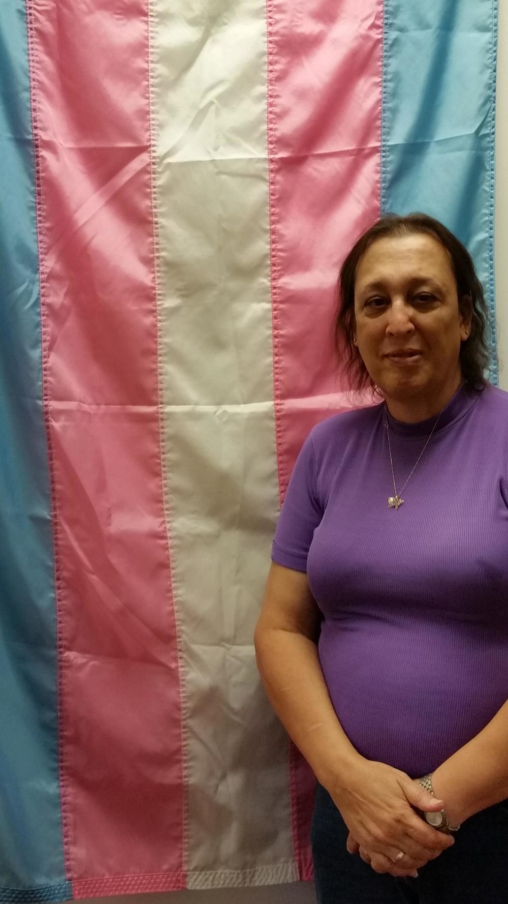 Helms poses with the transgender flag, which she created in 1999.