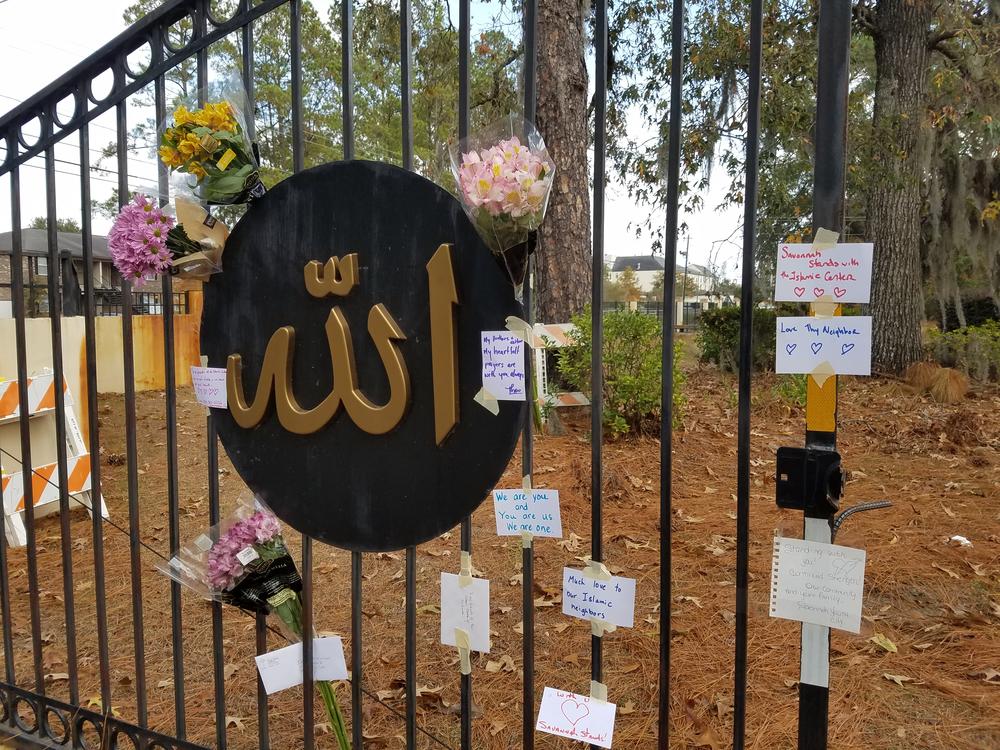 Flowers and notes of support hang on the fence of the Islamic Center of Savannah.