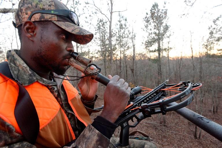 Edwin Pierre-Lewis, a graduate student at the University of Georgia, uses a buck call as he hunts deer west of Athens. He learned to hunt as part of the Field to Fork program and has become a mentor, now teaching others how to hunt.