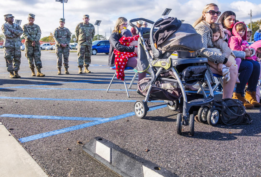 Spouses and children of members of the Georgia National Guard's 48th Brigade listen during a ceremony marking the brigades transition to serving under the Army's 3rd Infantry Brigade in Macon.