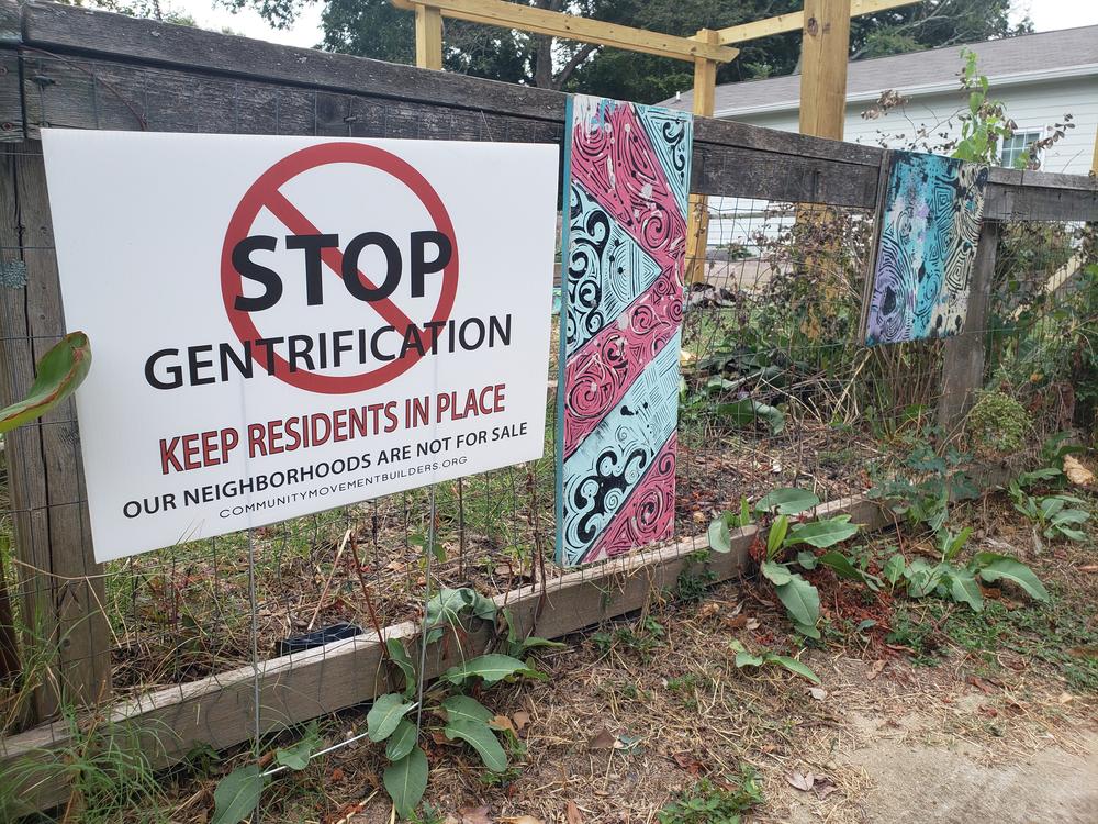 A sign sits outside of Welch Park in Atlanta calling for an end to gentrification. It was placed by an anti-gentrification group, Community Movement Builders.
