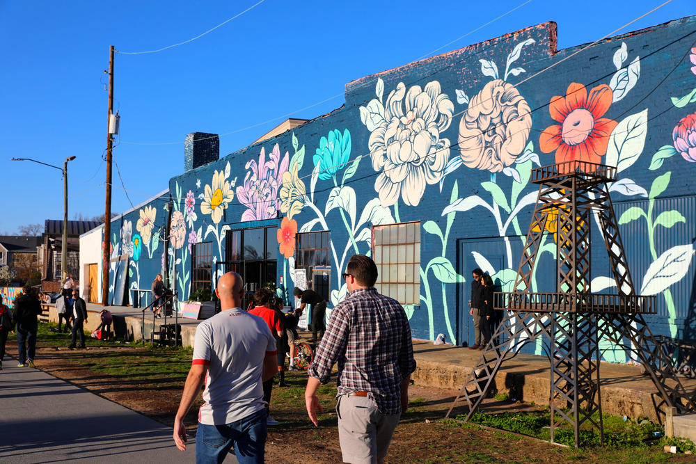 People walk alongside the Atlanta beltline on a sunny day