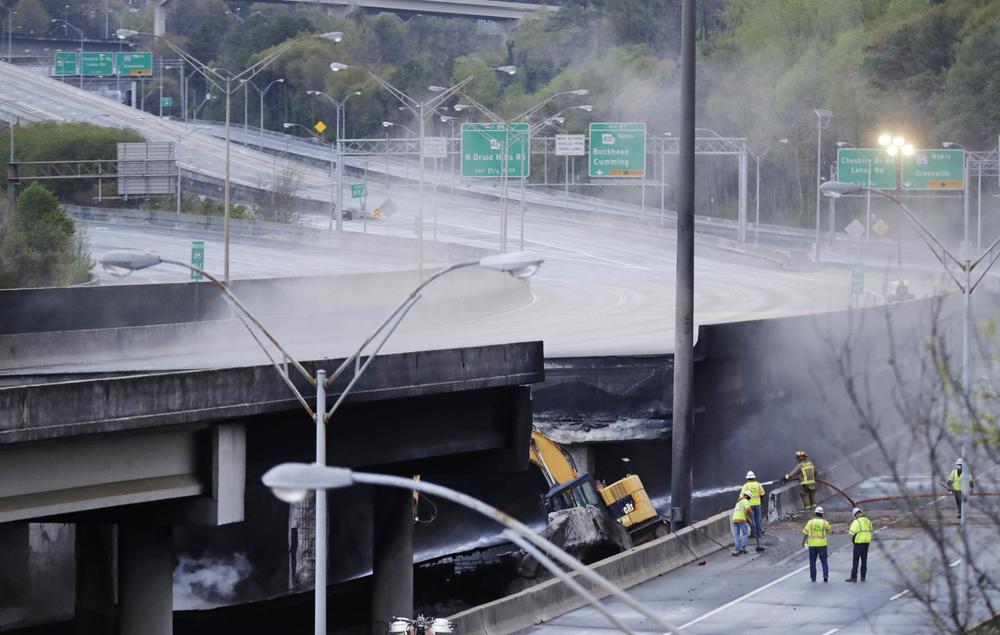 Crews inspect a section of an I-85 overpass in Atlanta that collapsed from a large fire, roiling traffic in the heart of the city. Officials have completely shut down the heavily traveled road.