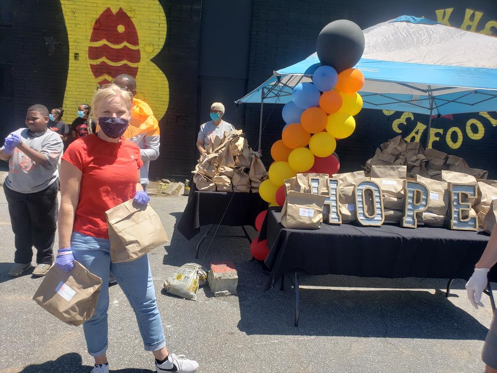 A volunteer passes out food outside Bankhead Seafood.