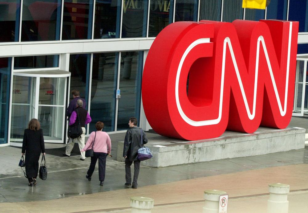 Pedestrians enter CNN Center, the headquarters for CNN, in downtown Atlanta, Wednesday, Jan. 17, 2001.