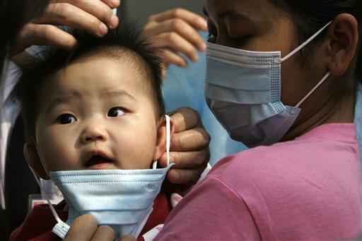 A baby wearing a mask as a preventative measure against a flu outbreak when entering a hospital in Hong Kong Sunday March 16, 2008. 