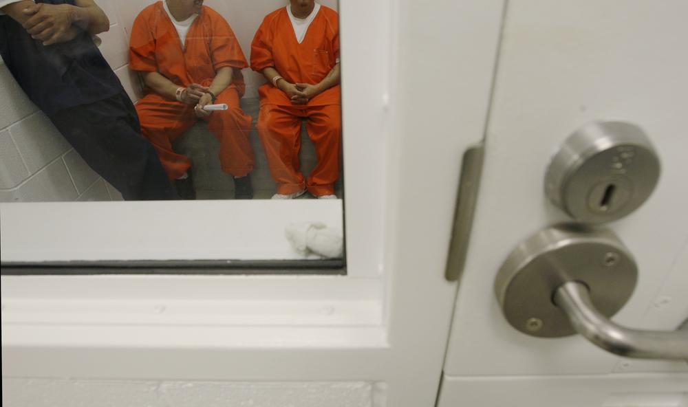 In this photo taken on Friday, Oct. 17, 2008, detainees are shown inside a holding cell at the Northwest Detention Center in Tacoma, Wash. The facility is operated by The GEO Group Inc. under contract from U.S. Immigrations and Customs Enforcement.