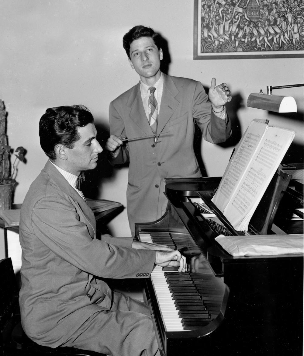 In this July 13, 1944, photo, Leonard Bernstein plays the piano during a rehearsal at his apartment in New York with 20-year-old conductor and composer Lukas Foss.