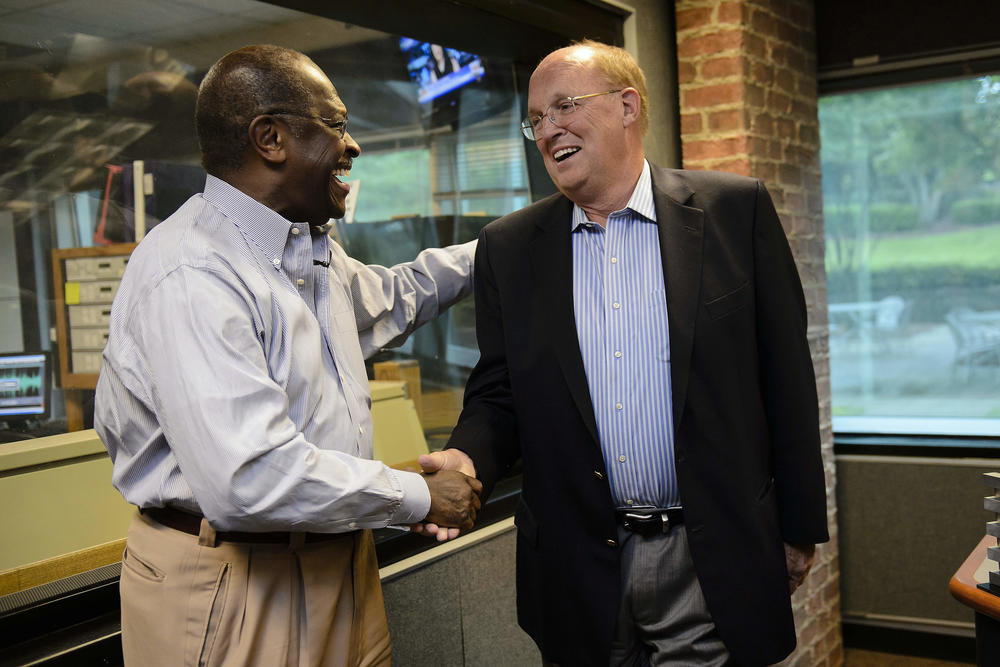 Former Republican Presidential candidate Herman Cain shakes hands with news talk radio host Neal Boortz after he was announced as Boortz's replacement following Boortz's retirement announcement during his morning show at WSB in Atlanta in 2012.