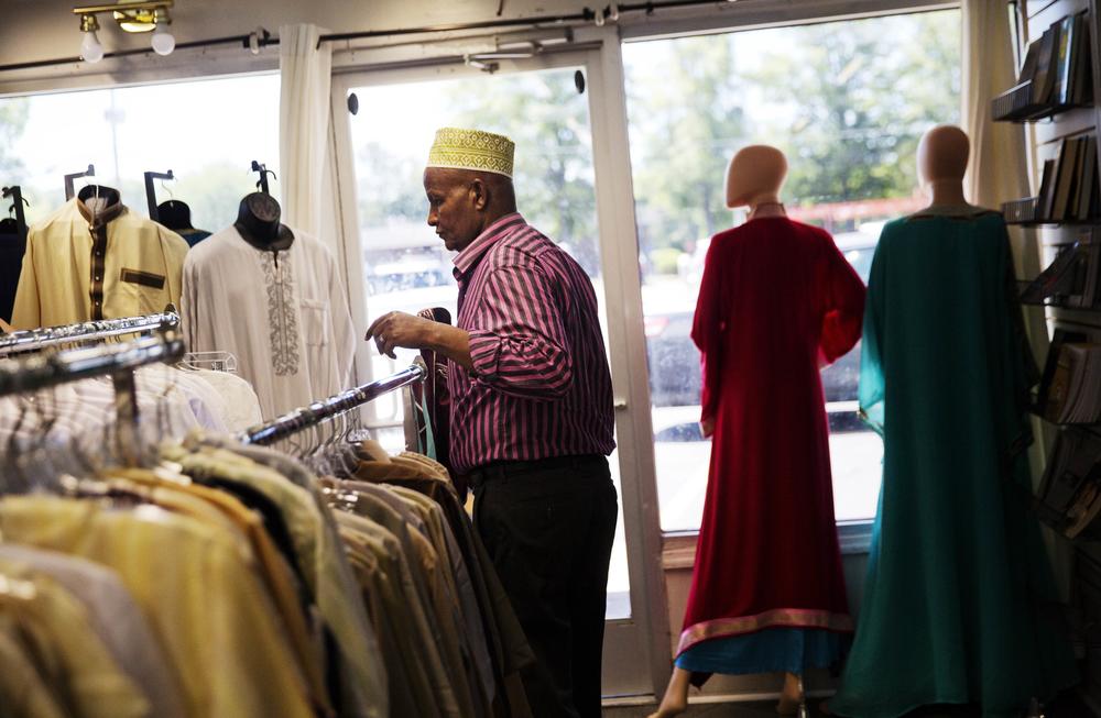 Mohamoud Saed, a refugee from Somalia, helps out in a friend's clothing store in Clarkston, Ga. He was a doctor in Somalia before he fled the nation's civil war, anxiously awaits the arrival of his wife and children while struggling with kidney issues.