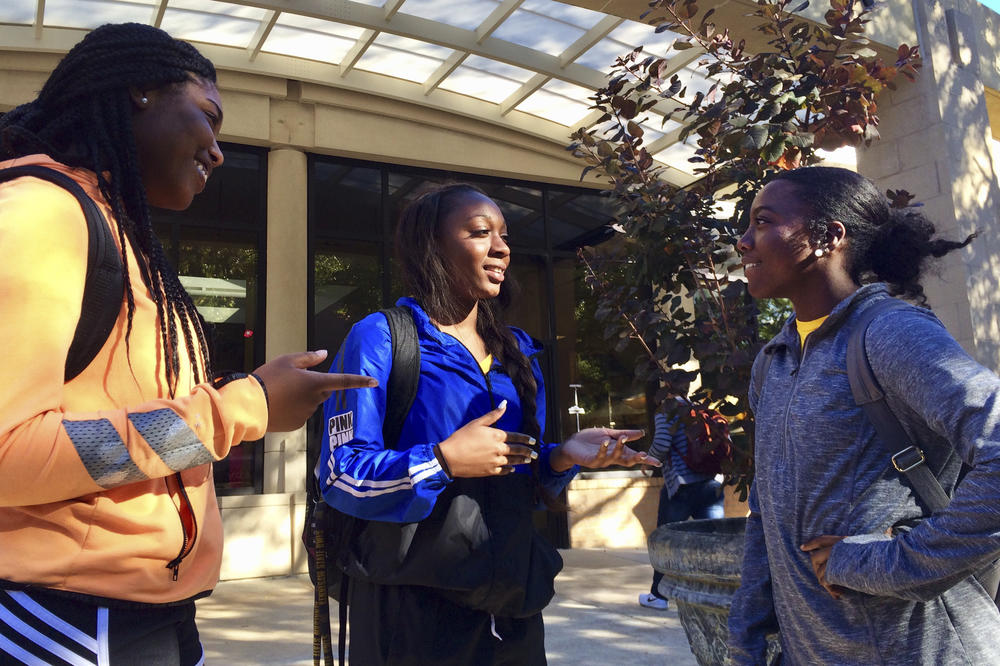 Kennesaw State University cheerleaders, from left to right, Shlondra Young, Tommia Dean and Kennedy Town stand outside the student center on the school's campus in Kennesaw, Ga.