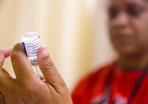 In this Wednesday, Feb. 7, 2018 file photo, a nurse prepares a flu shot from a vaccine vial at the Salvation Army in Atlanta. 