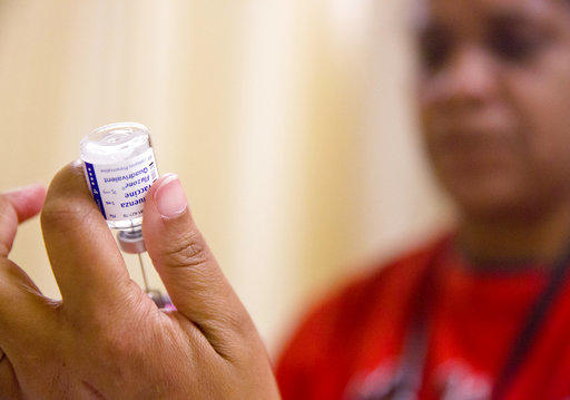 A nurse prepares a flu shot from a vaccine vial at the Salvation Army in Atlanta.