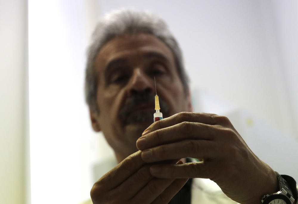 Doctor Roberto Ieraci checks a syringe before vaccinating a child. Georgia has confirmed 11 cases of measles this year, which is more than the state has seen in the past decade.