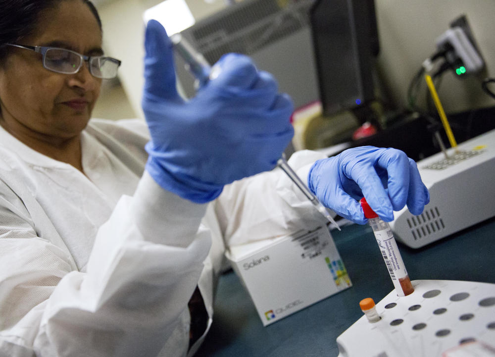 In a Friday, Feb. 9, 2018 file photo, lab technologist Sharda Modi tests a patient's swab for a flu infection at Upson Regional Medical Center in Thomaston, Georgia.