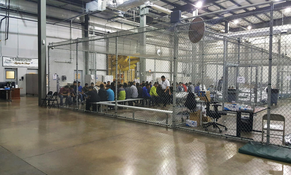 In this photo provided by U.S.People who've been taken into custody related to cases of illegal entry into the United States sit in one of the cages at a facility in McAllen, Texas, Sunday, June 17, 2018.