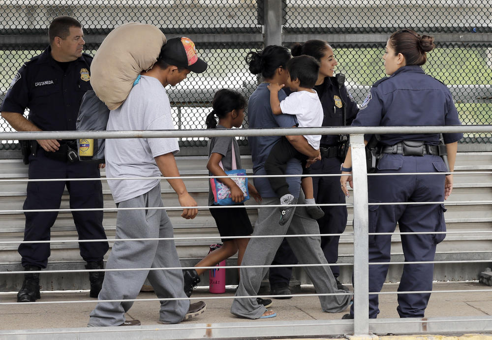 Ever Castillo, left, and his family, immigrants from Honduras, are escorted back across the border by U.S. Customs and Border Patrol agents Thursday, June 21, 2018, in Hildalgo, Texas. 