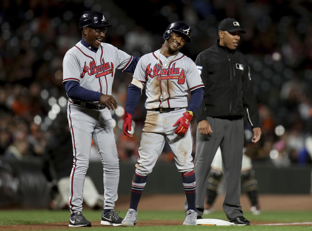 Atlanta Braves shortstop Ozzie Albies (1) and Atlanta Braves third base coach Ron Washington (37) smile after Albies doubled and advanced to third on a throwing error by Gorkys HernÃ¡ndez in the seventh inning of a baseball game in San Francisco.