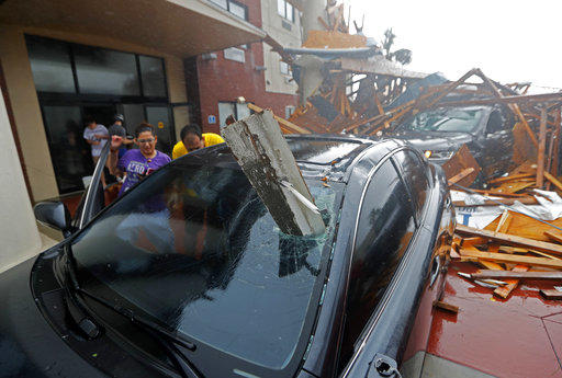 A woman checks on her vehicle as Hurricane Michael passes through, after the hotel canopy had just collapsed, in Panama City Beach, Fla., Wednesday.