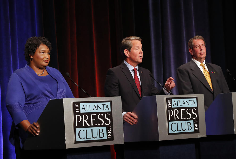 Republican gubernatorial candidate for Georgia Secretary of State Brian Kemp, center, speaks as Democrat Stacey Abrams, left, and Libertarian Ted Metz look on during a debate Tuesday, Oct. 23, 2018, in Atlanta. 