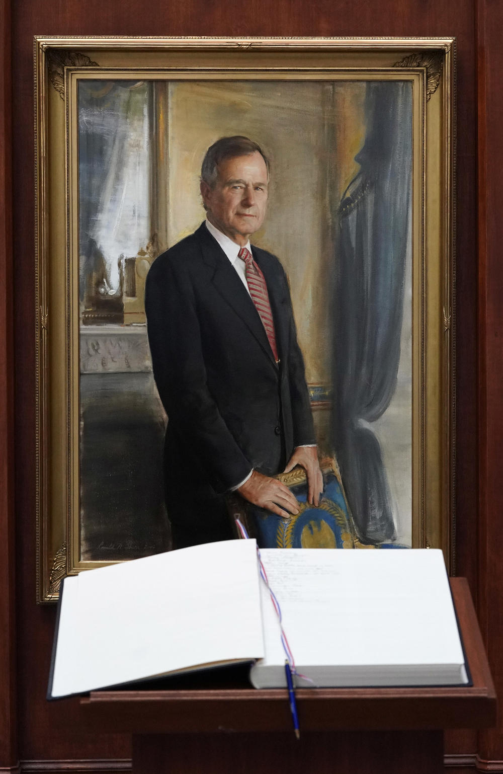 A condolence book sits in front of a painting of George H.W. Bush inside the George H.W. Bush Library and Museum Saturday, Dec. 1, 2018, in College Station. Bush has died at age 94. 