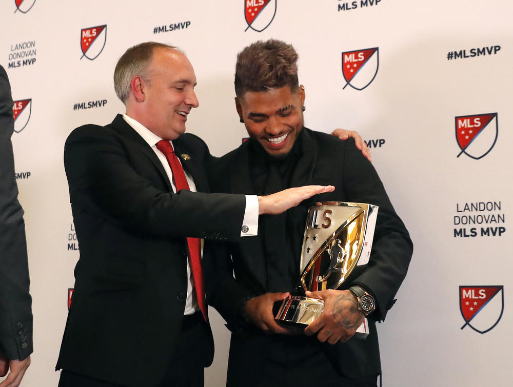 Josef Martinez laughs with Atlanta United President Darren Eales after receivng the MVP trophy.