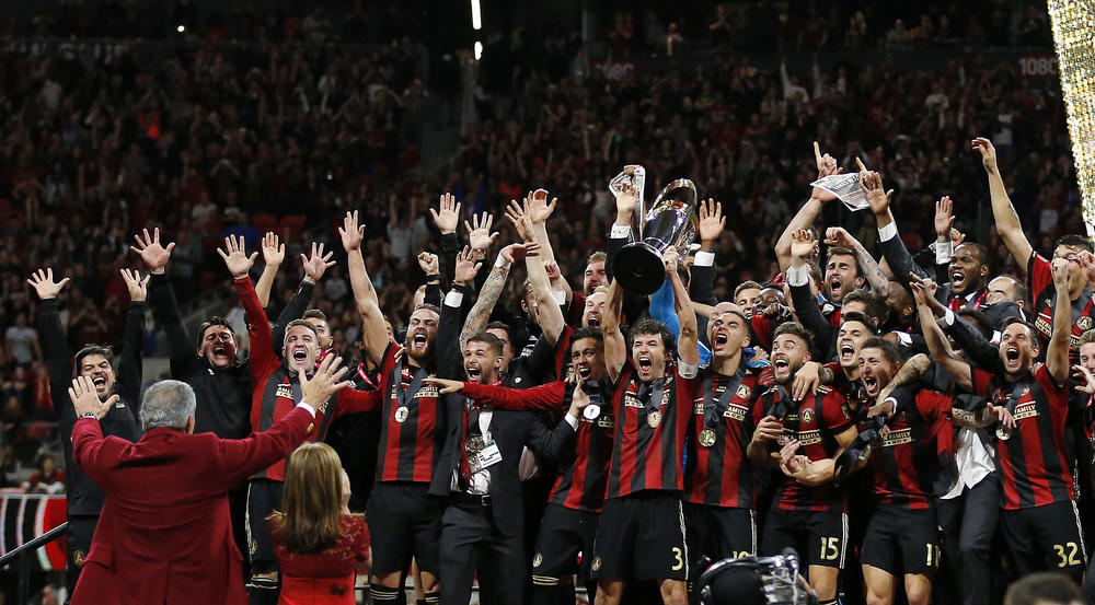 The Atlanta United celebrate their MLS Cup victor in front of team owner Arhtur Blank.
