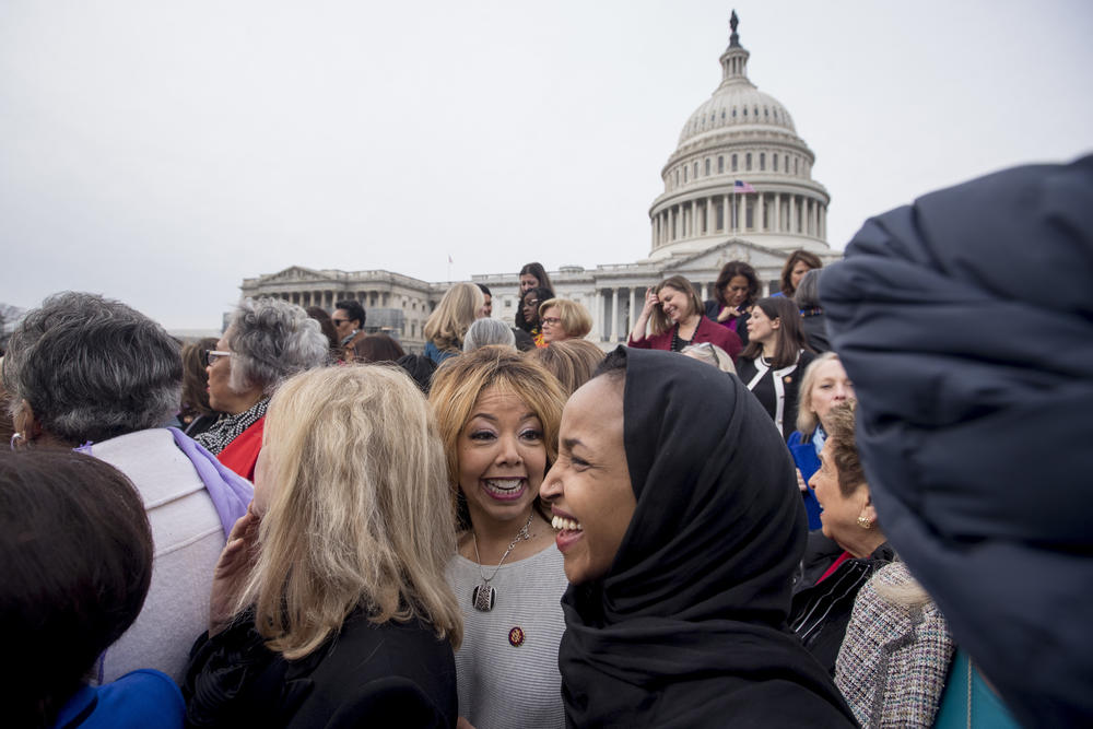 Rep. Lucy McBath, D-Ga., center, smiles with Rep. Ilhan Omar, D-Minn., second from right, following a group portrait in Washington as the 116th Congress begins.