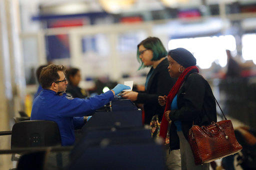 A Transportation Security Administration employee checks in air travelers at Hartsfield Jackson Atlanta International Airport Monday, Jan. 7, 2019, in Atlanta. 