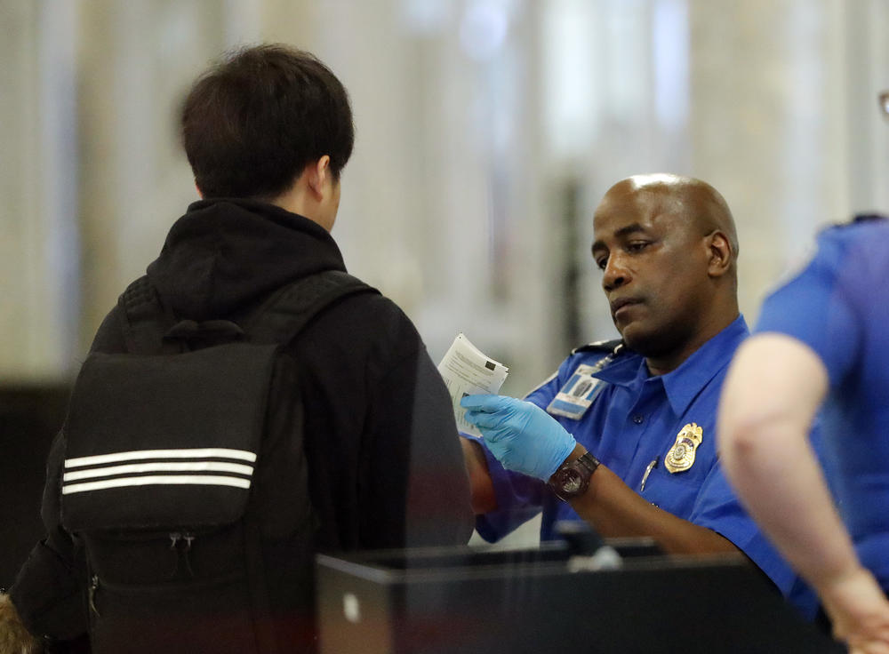 A Transportation Security Administration employee checks an air traveler's identification at Hartsfield Jackson Atlanta International Airport Monday, Jan. 7, 2019, in Atlanta.