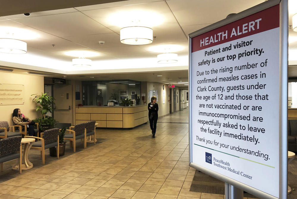 In this Jan. 25, 2019 file photo, a sign prohibiting all children under 12 and unvaccinated adults stands at the entrance to PeaceHealth Southwest Medical Center in Vancouver, Wash. Measles has been confirmed in Cobb County, Georgia, Nov. 9, 2019. 