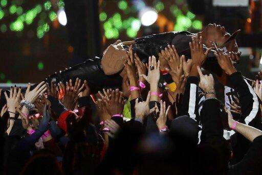 Travis Scott is carried by the crowd during halftime show of the NFL Super Bowl 53 football game between the Los Angeles Rams and the New England Patriots Sunday, Feb. 3, 2019, in Atlanta.