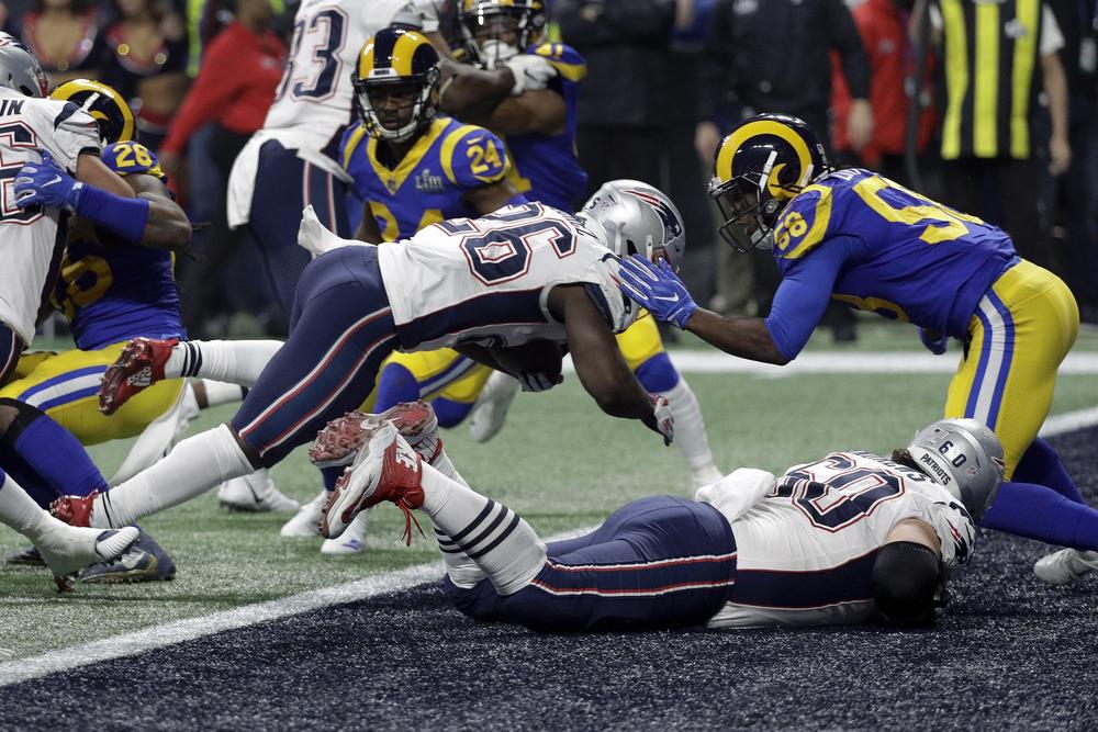 New England Patriots' Sony Michel (26) dives over the goal line for a touchdown in front of Los Angeles Rams' Cory Littleton (58) during the second half of the NFL Super Bowl 53 football game Sunday, Feb. 3, 2019, in Atlanta.