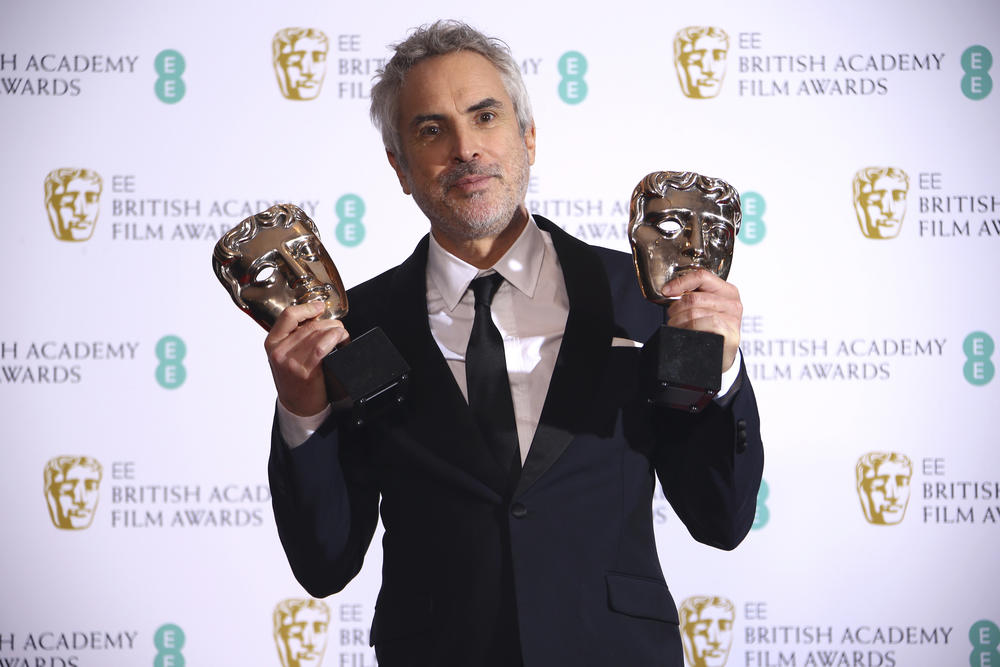 Director Alfonso Cuaron poses for photographers backstage with his Best Film and Best Director award for his film 'Roma' at the BAFTA awards in London, Sunday, Feb. 10, 2019.