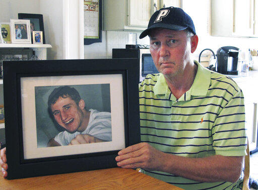 Dean Palozej poses with a photo of his son, Spencer, in Stafford, Conn. Spencer Palozej died of a fentanyl overdose in 2018.